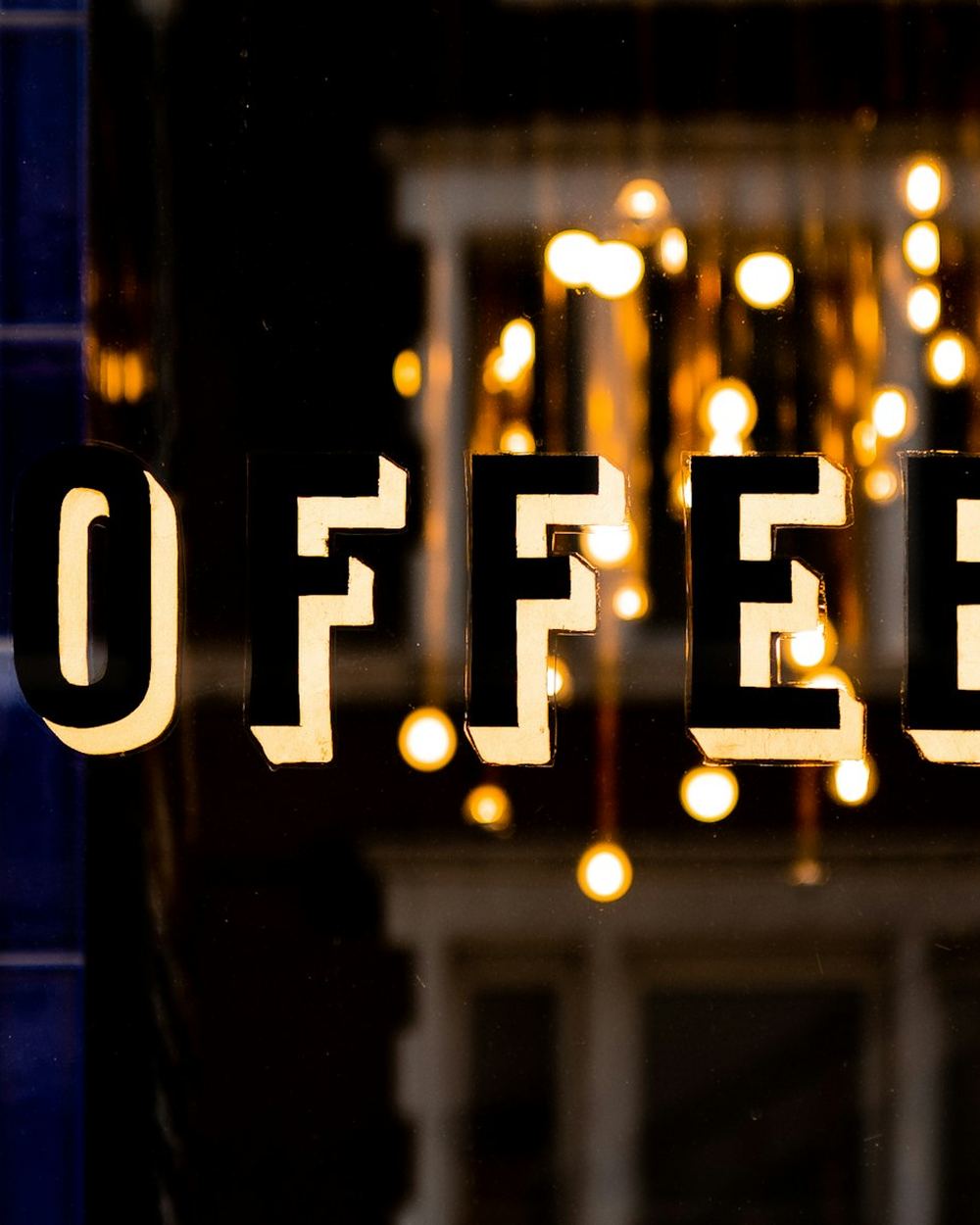 A lit COFFEE sign in a shop window