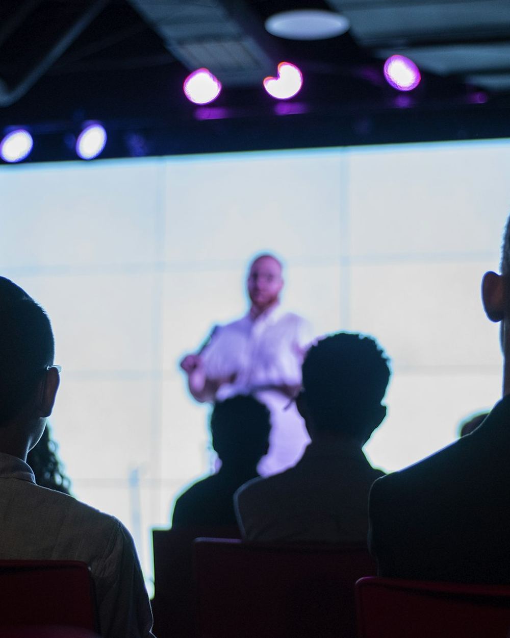 An audience facing a lit stage at an event