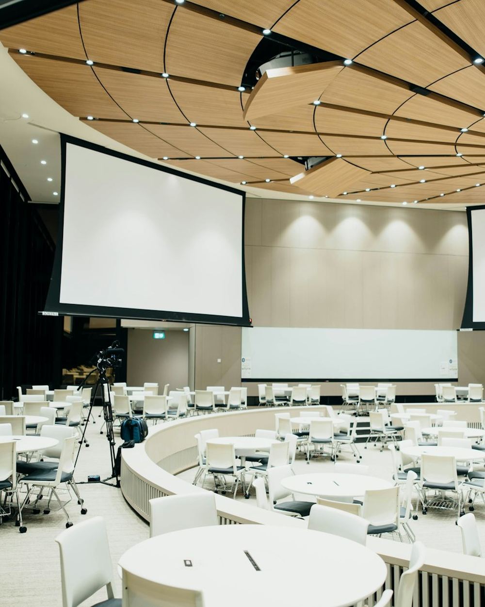 A large conference room set with round tables