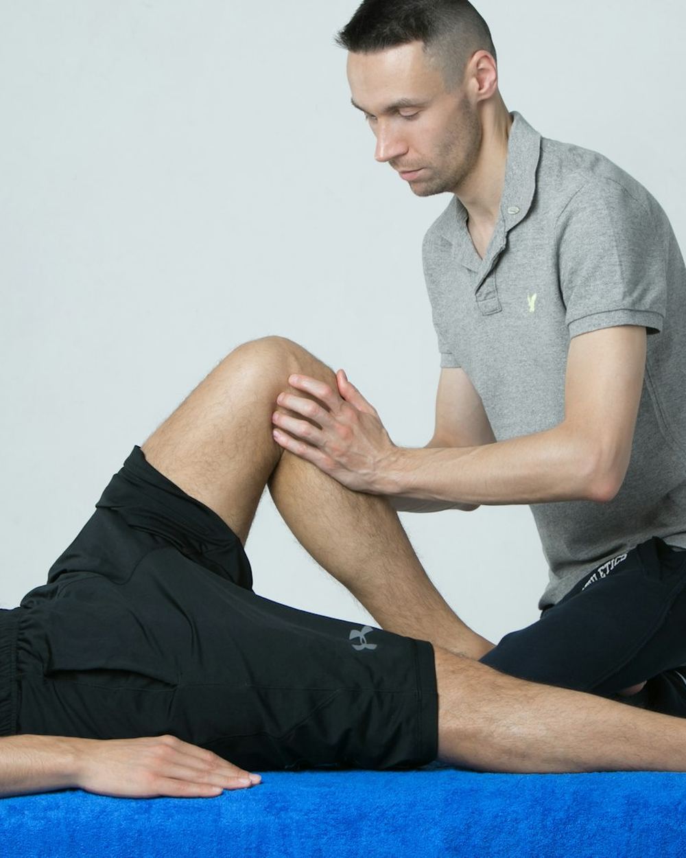 A physical therapist working on a patient's knee